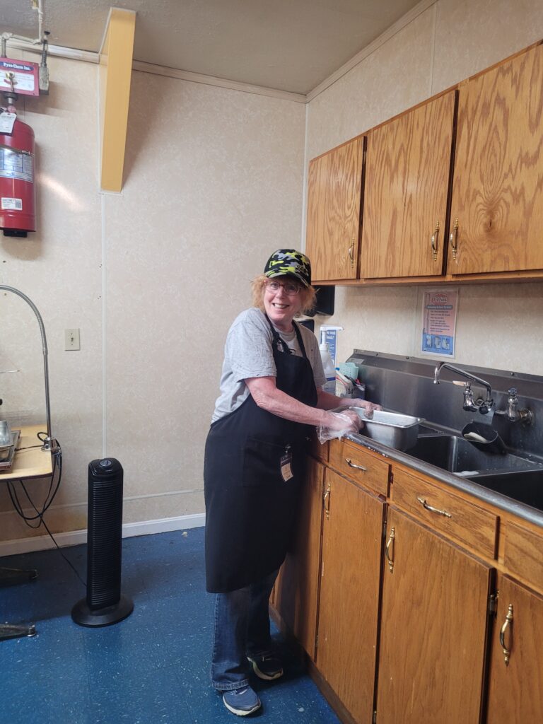 Woman Smiling while holding the dishes